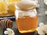 a jar of honey on a wooden table