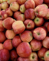 many red apples are piled up in a pile